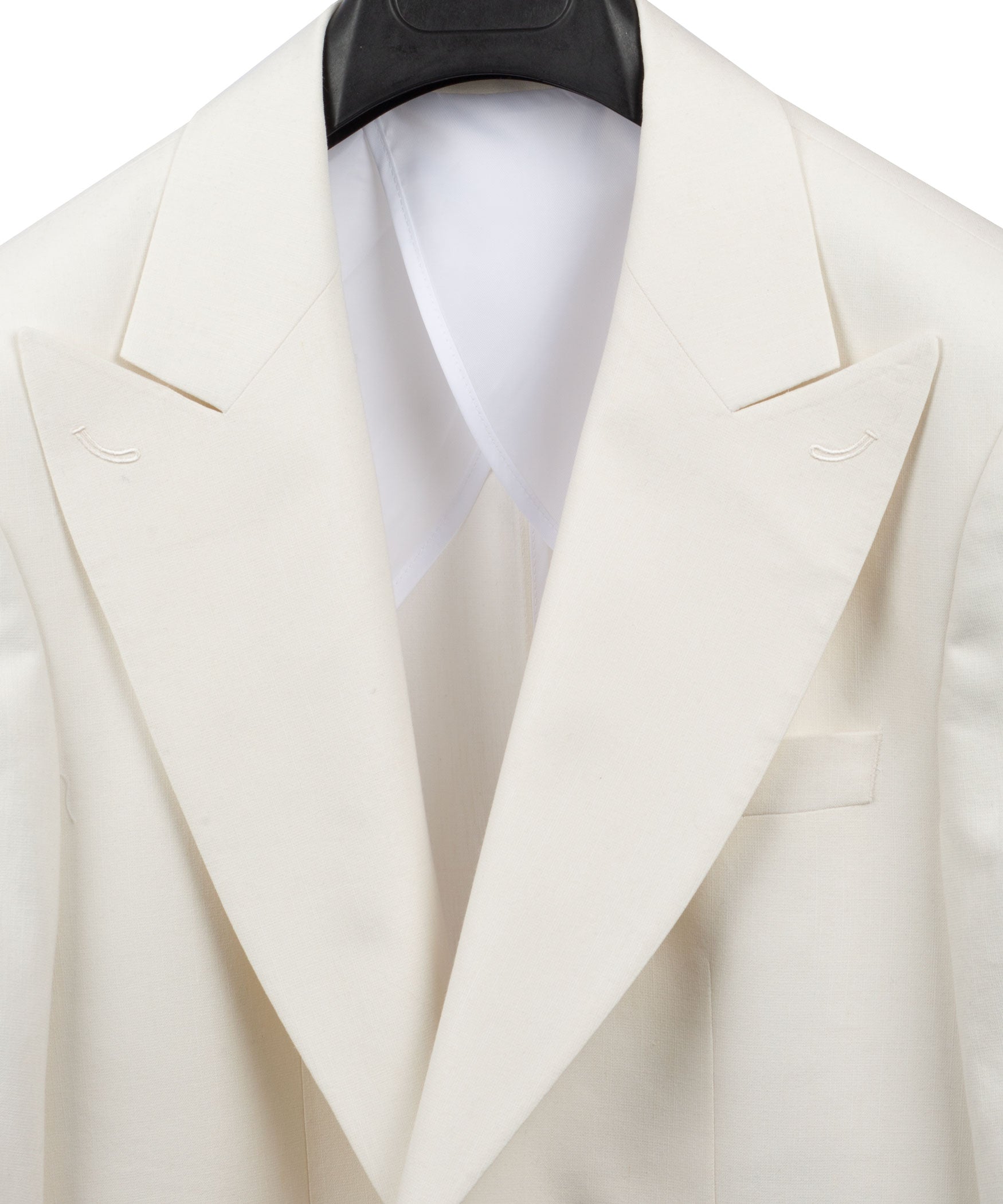 Cream linen blazer close-up of peaked lapels and welt pockets with white shirt collar