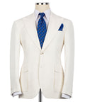 Cream linen blazer with notch lapels, flap pockets, and blue tie + pocket square