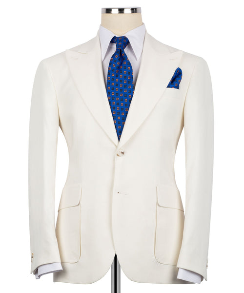 Cream linen blazer with notch lapels, flap pockets, and blue tie + pocket square