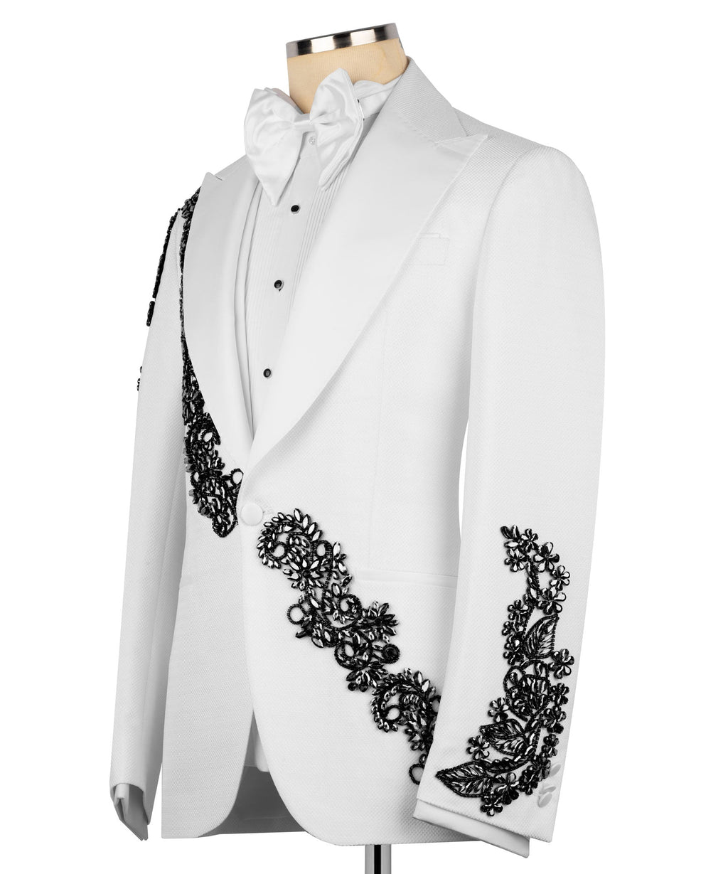 White tuxedo jacket with black floral stone embroidery along lapel and cuffs, bow tie