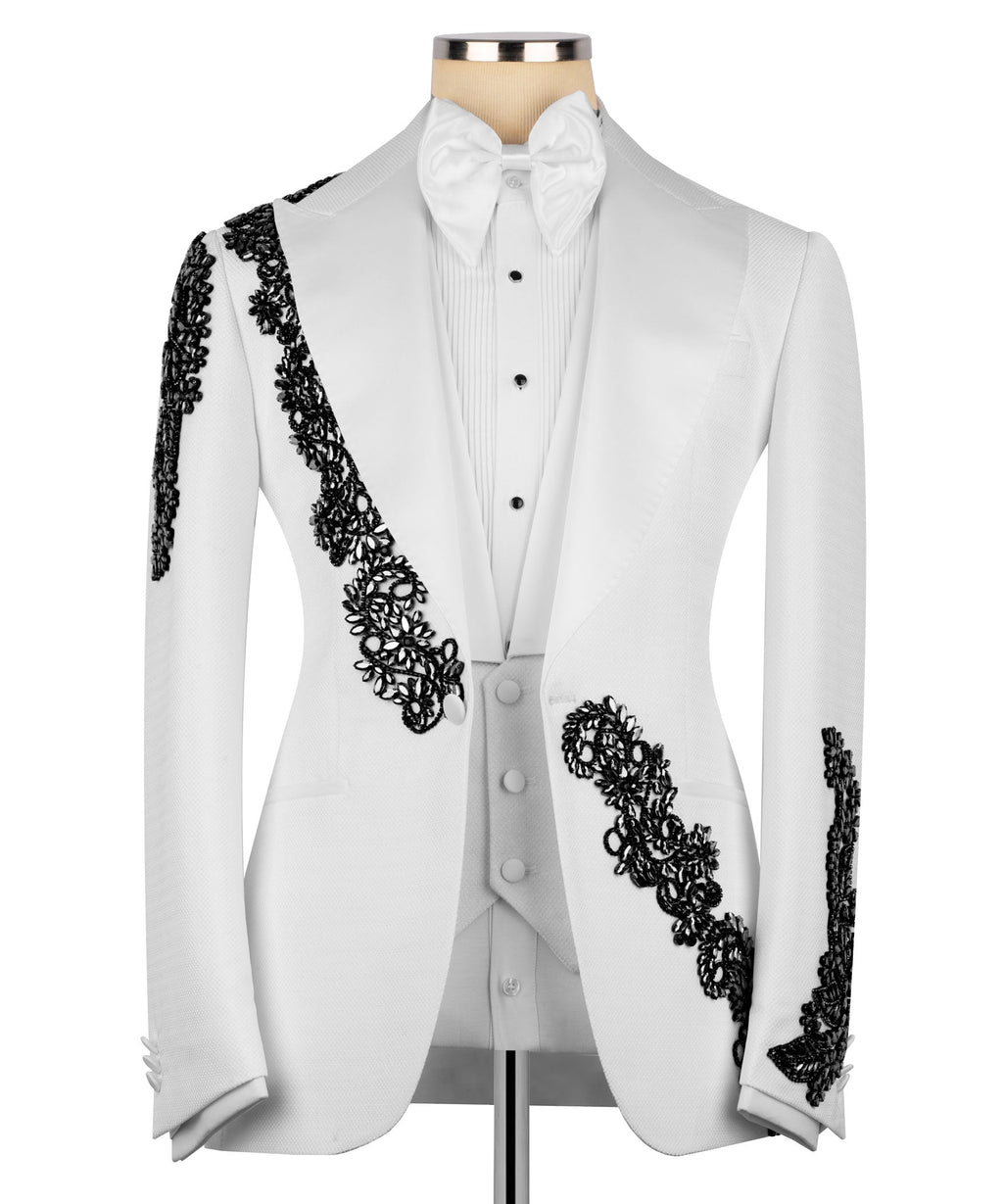 White tuxedo jacket with black stone-embroidered accents on lapel, waist, and sleeve