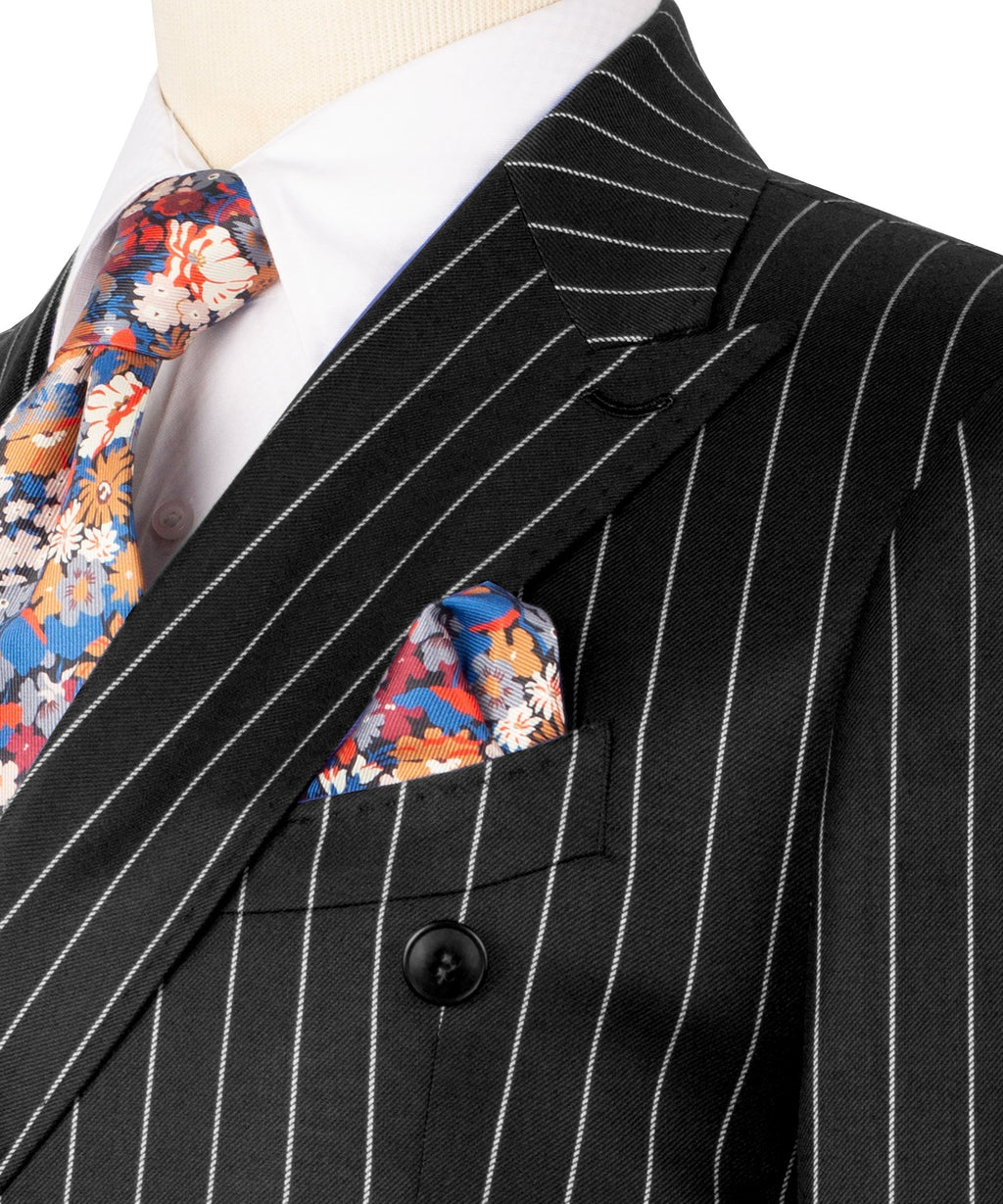 Black pinstripe suit jacket lapel with colorful floral pocket square and tie