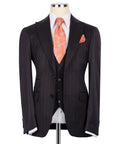 Dark pinstripe 3-piece suit jacket with buttoned vest and orange patterned necktie
