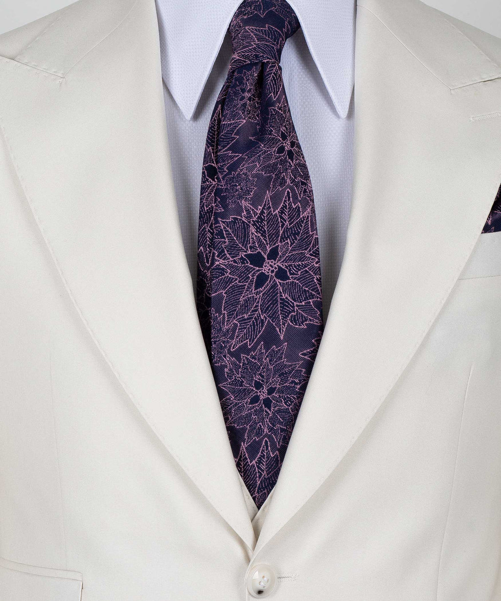 Close-up of cream vest lapels with purple patterned tie and white dress shirt collar