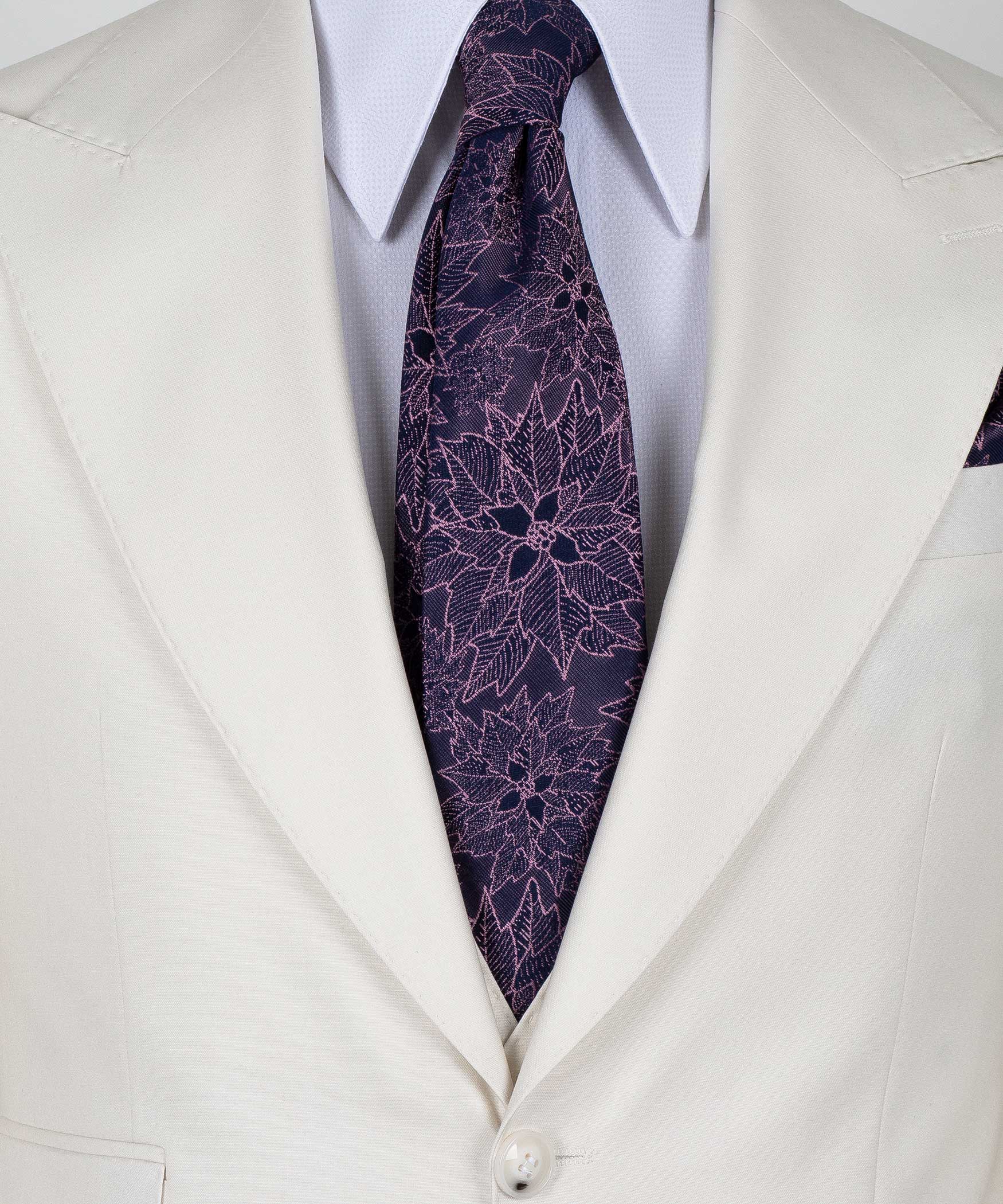 Close-up of cream vest lapels with purple patterned tie and white dress shirt collar