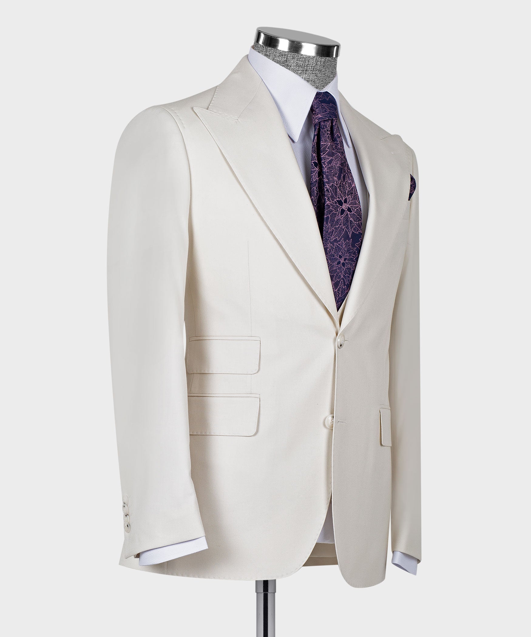 Side view of cream tailored blazer with matching vest, purple patterned tie and slim lapels