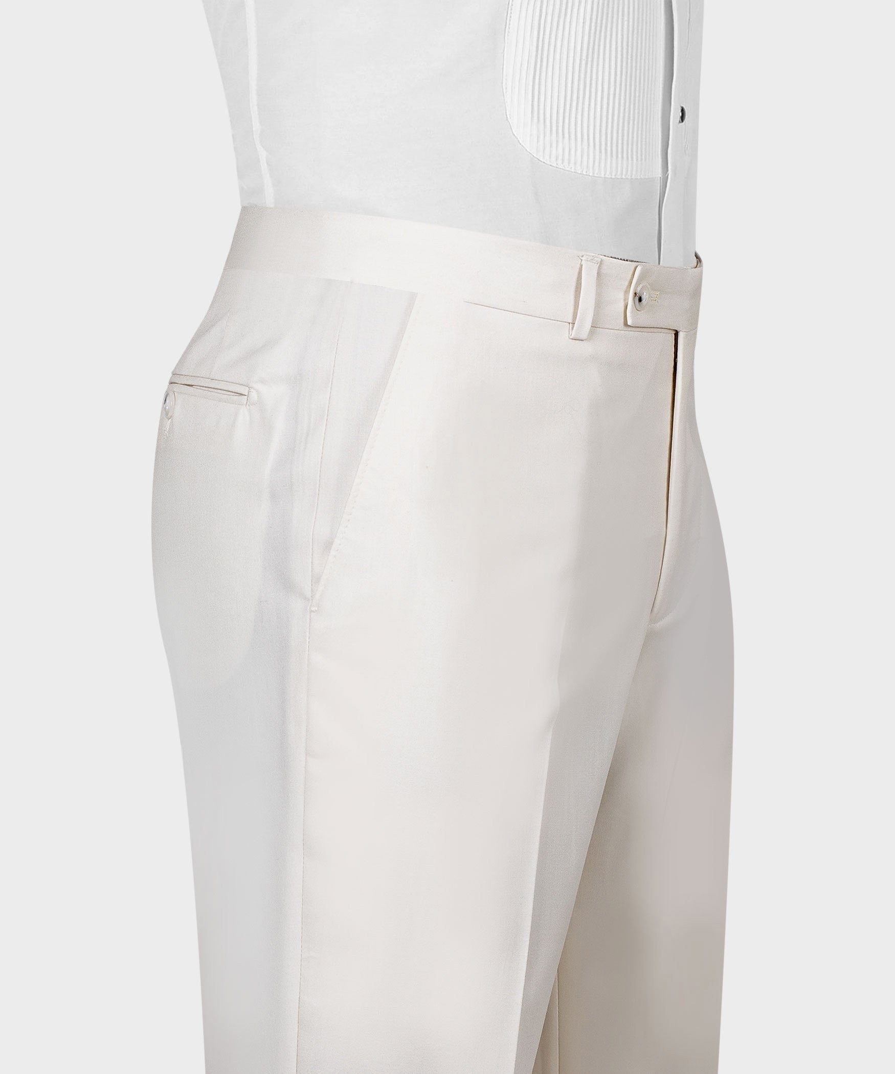 Cream tailored dress trousers close-up with waistband tab and front pleat detail