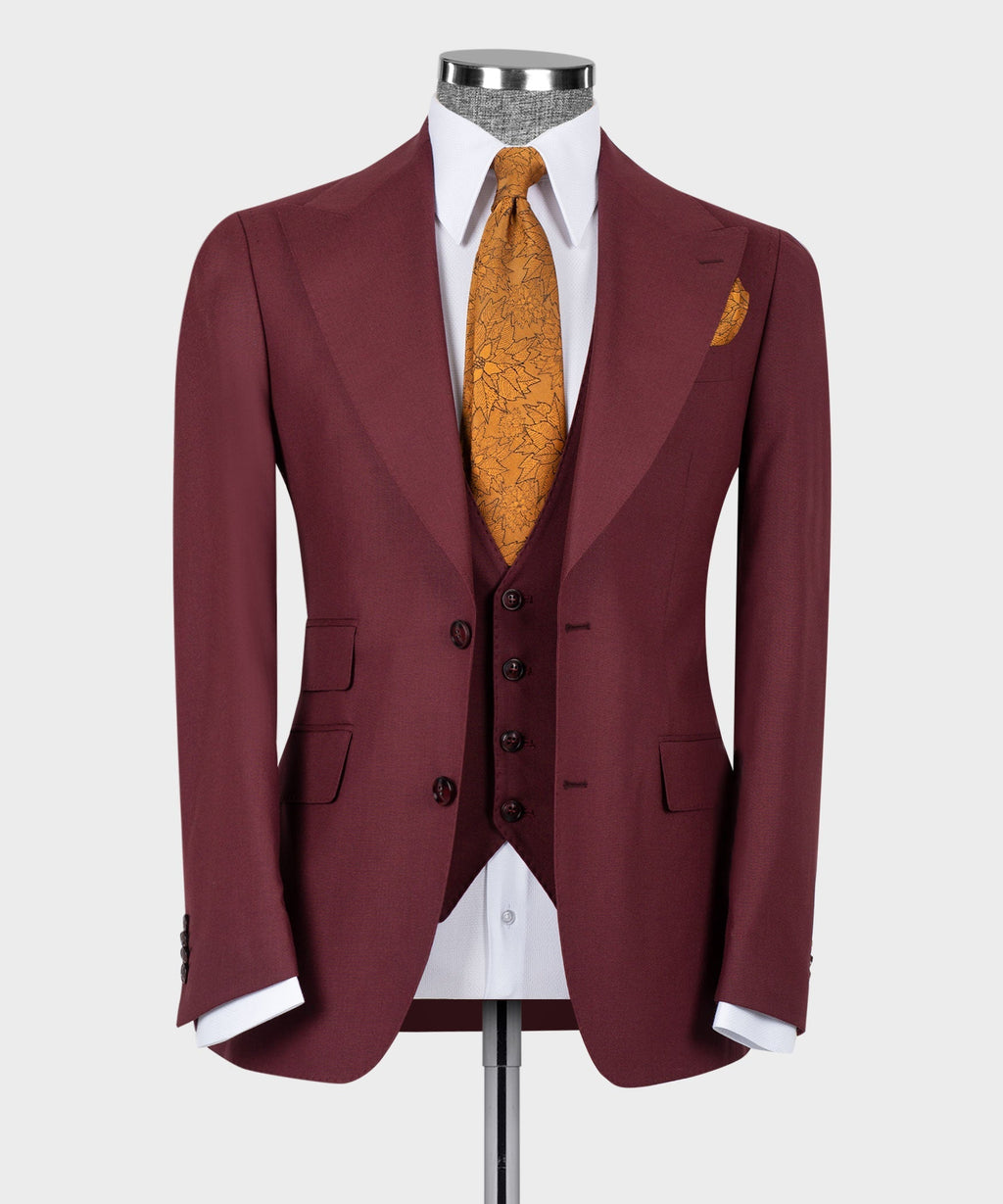 Burgundy tailored suit jacket with white shirt, mustard patterned tie, dark vest