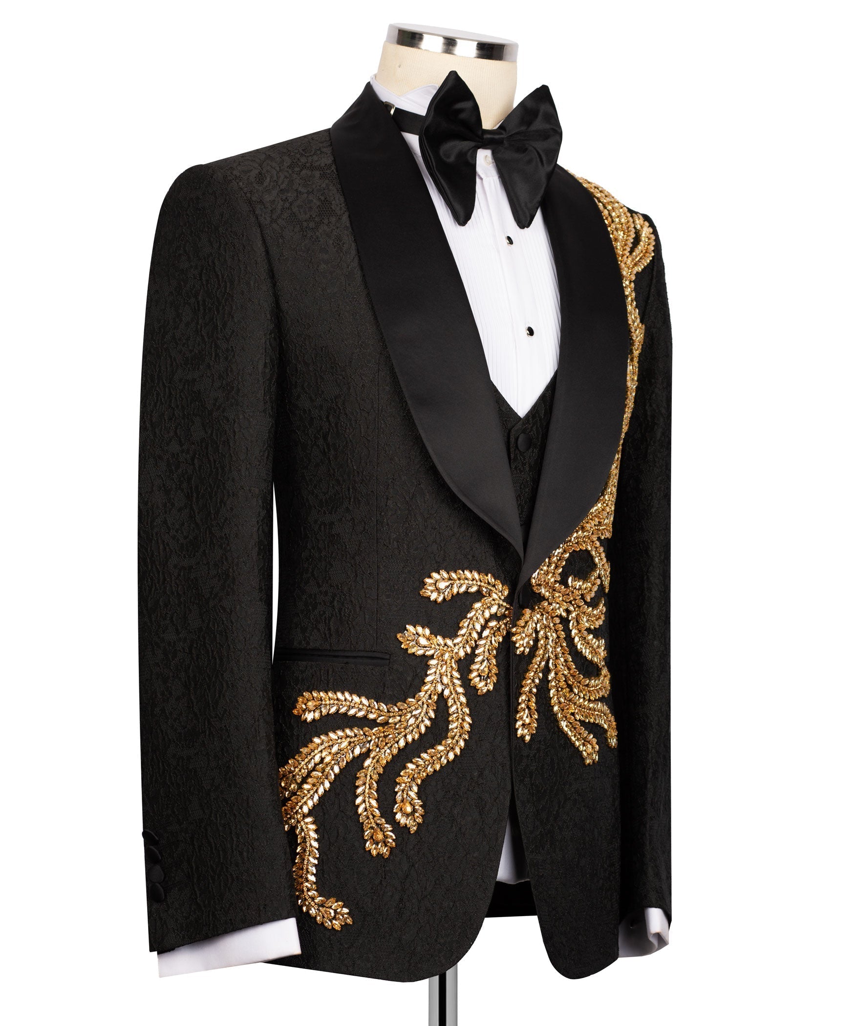 Black tuxedo jacket with gold embroidered crest on satin lapel; white shirt and bow tie