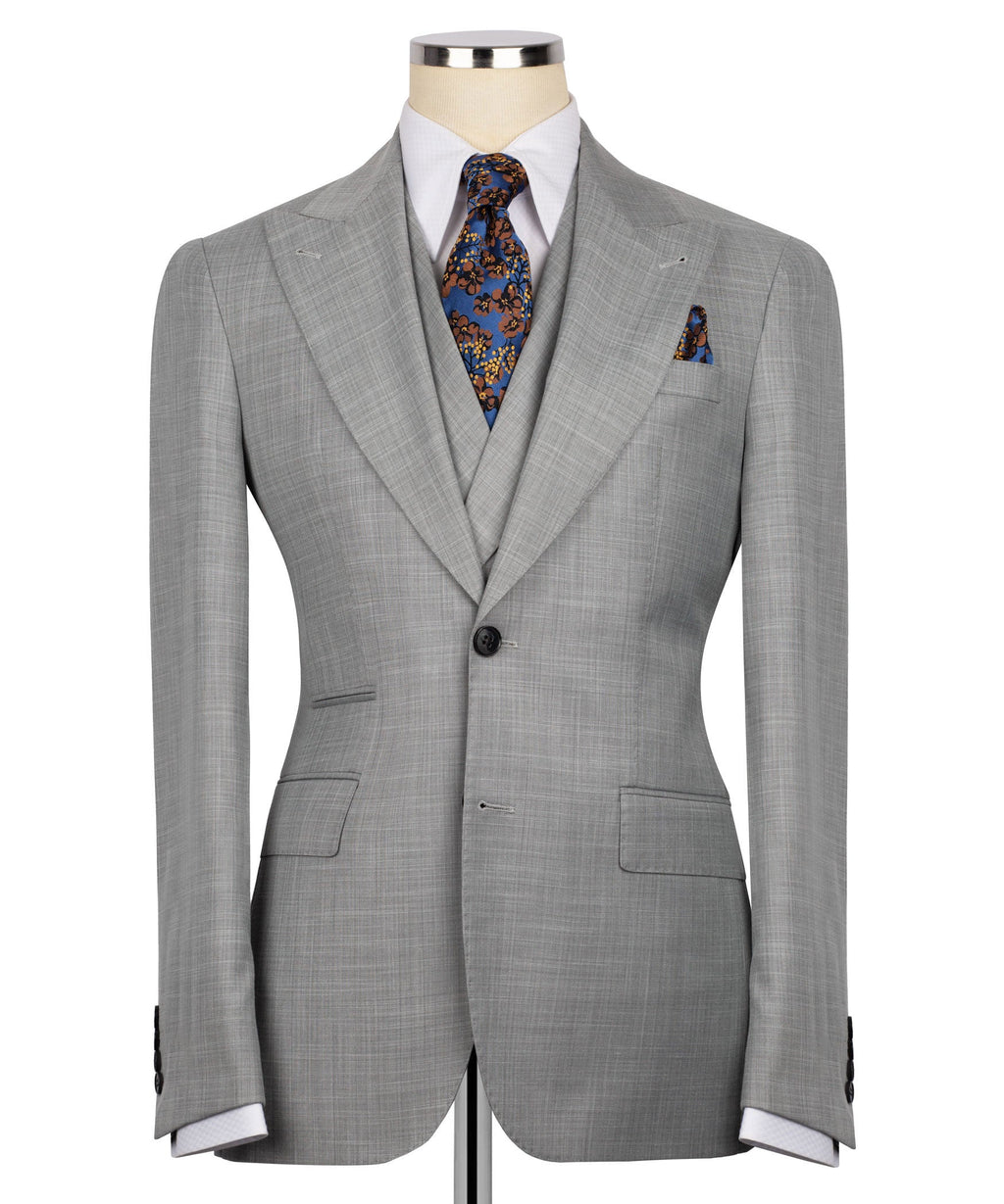 Grey suit jacket with notch lapels, dark buttons, and patterned tie at collar
