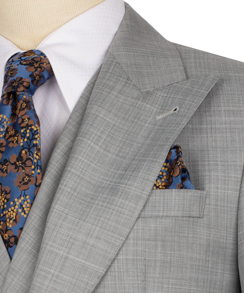 Grey suit lapel detail with patterned tie and blue floral pocket square