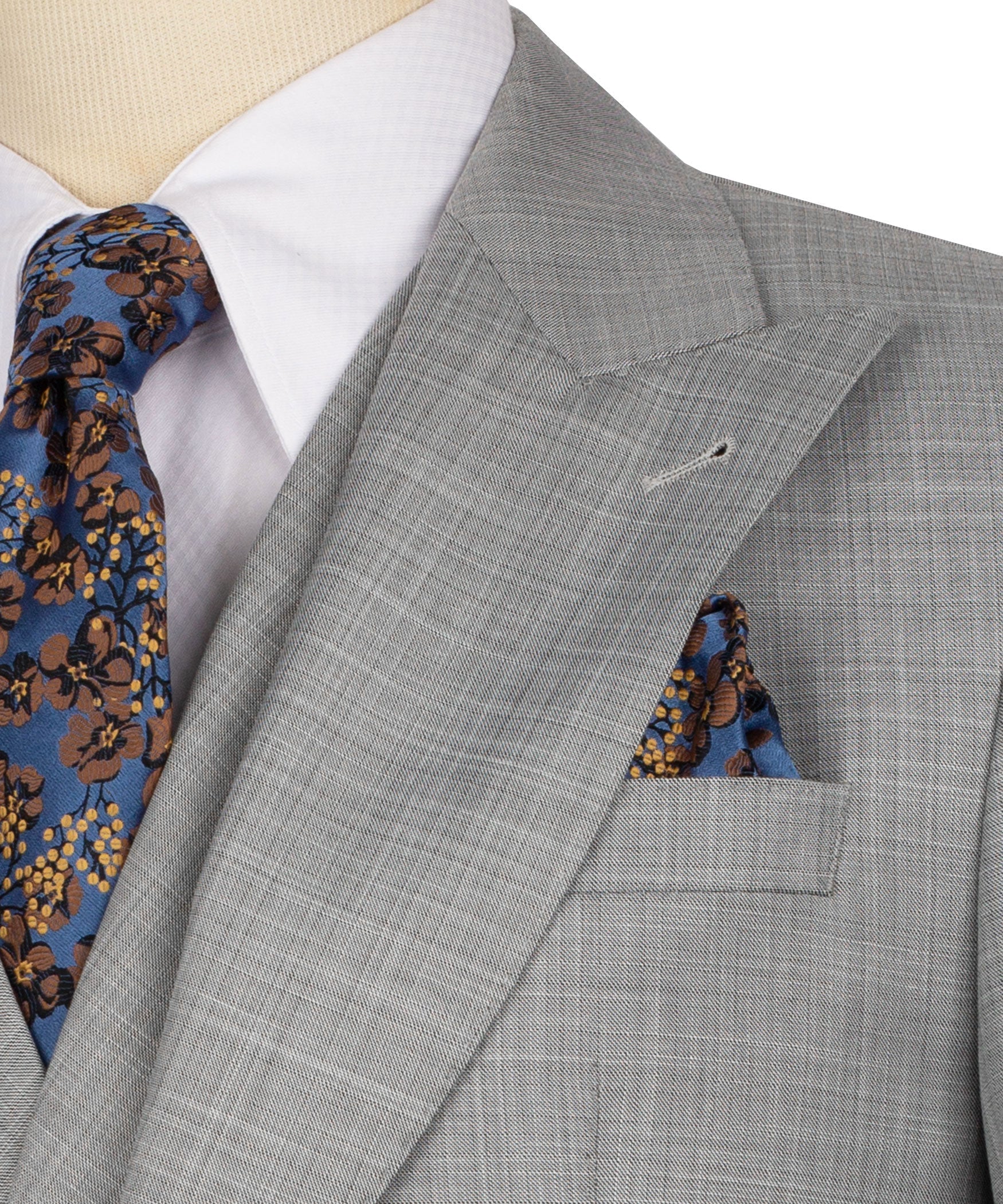 Grey suit lapel detail with patterned tie and blue floral pocket square