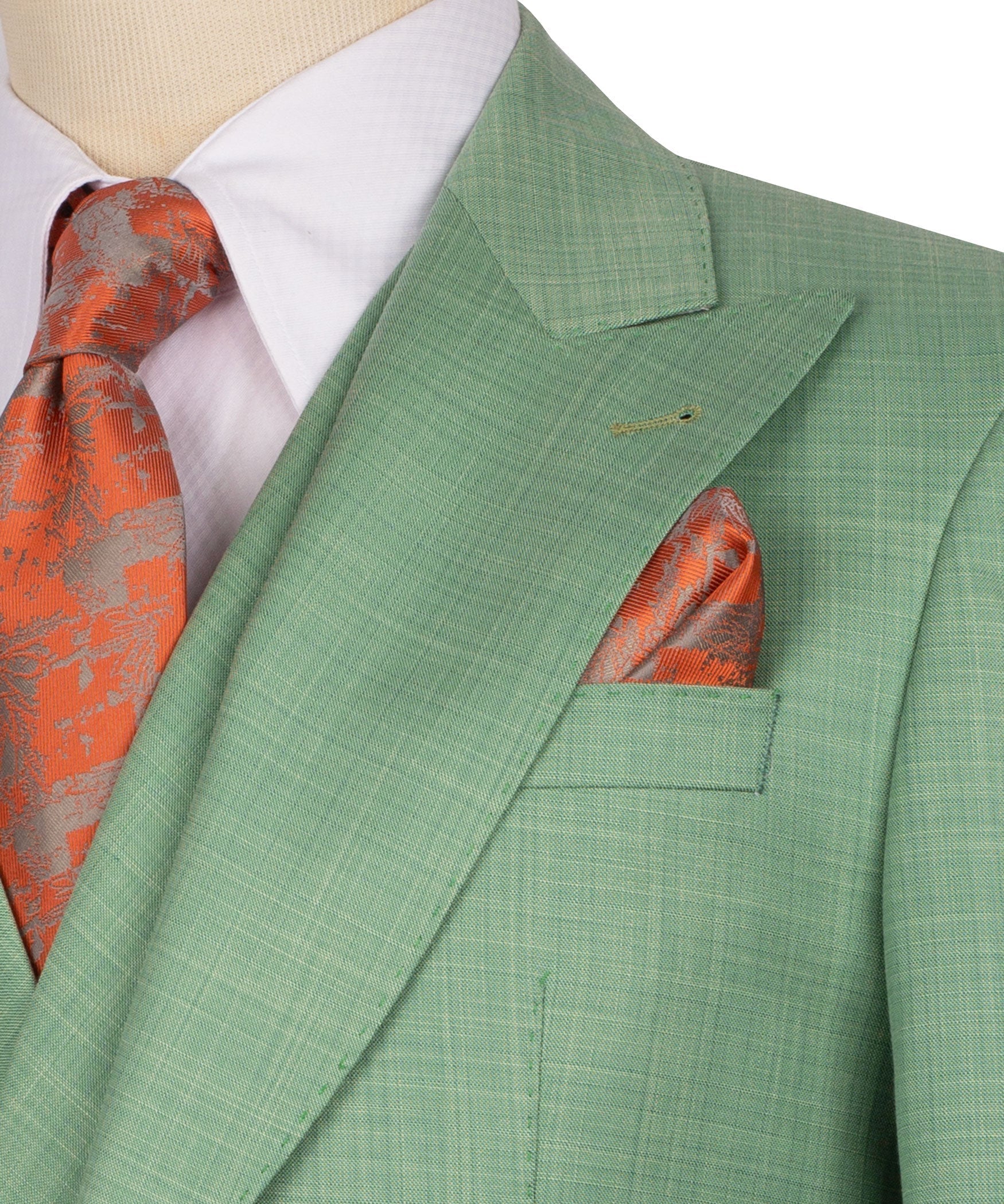 Green jacket lapel and chest pocket with orange patterned pocket square