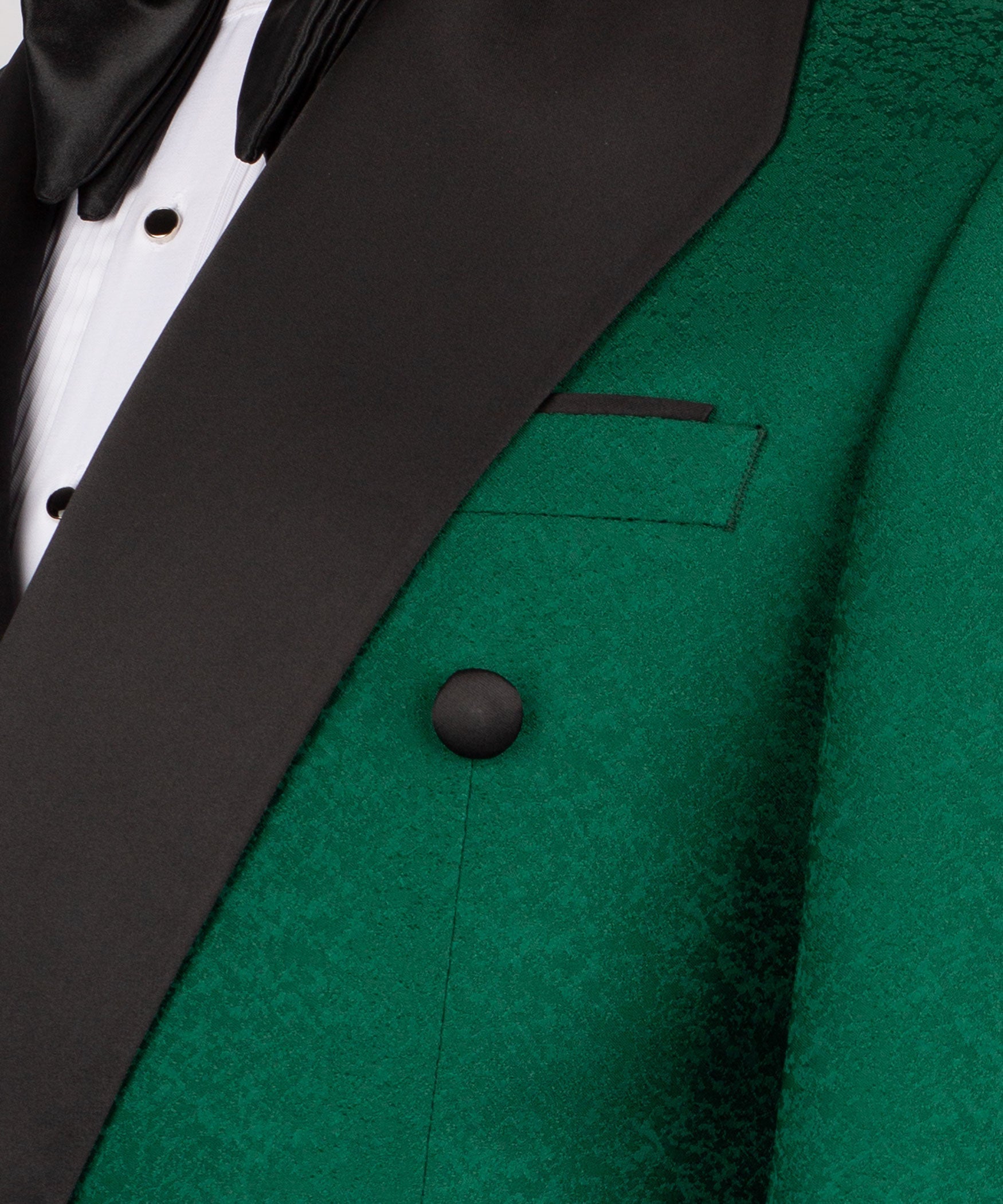 Close-up of green tuxedo jacket lapel, black vest panel, and dark button