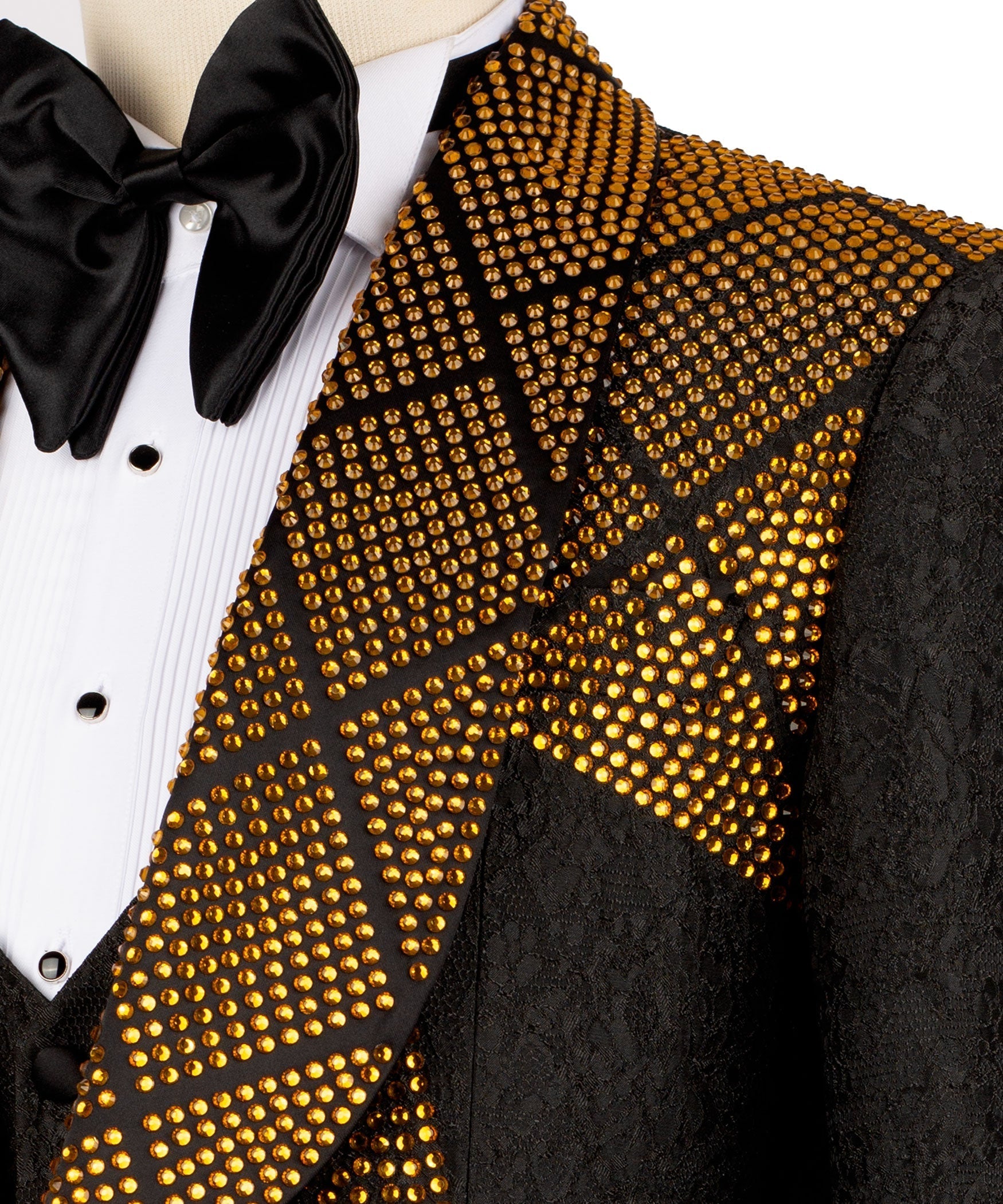 Gold stone-embroidered lapel detail on black tuxedo jacket, bow tie and shirt