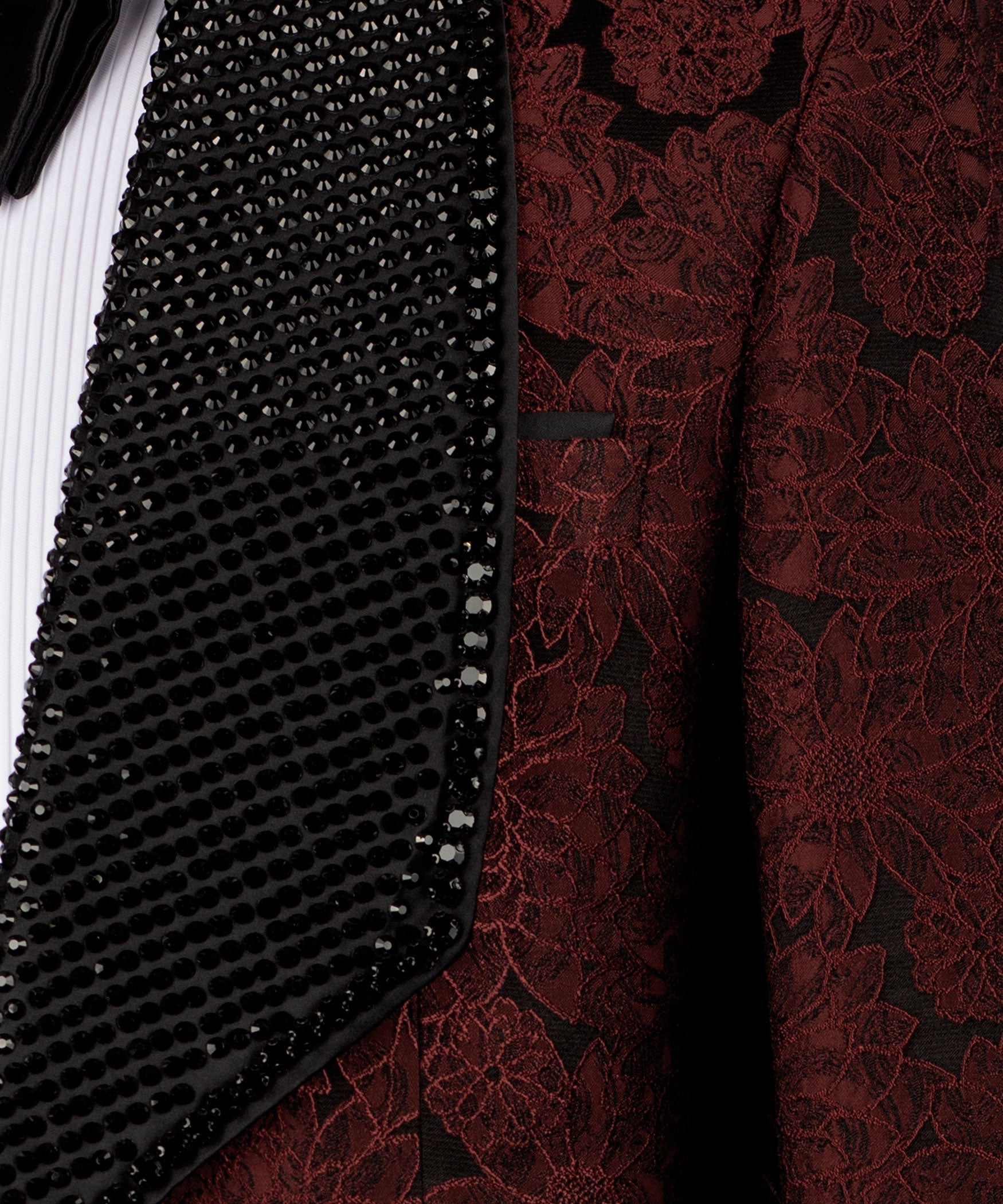 Close-up: black sequined velvet trim over red embroidered vest fabric