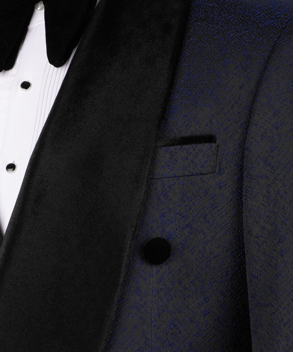 Close-up of black velvet tuxedo collar, lapel, and vest button on dark navy fabric