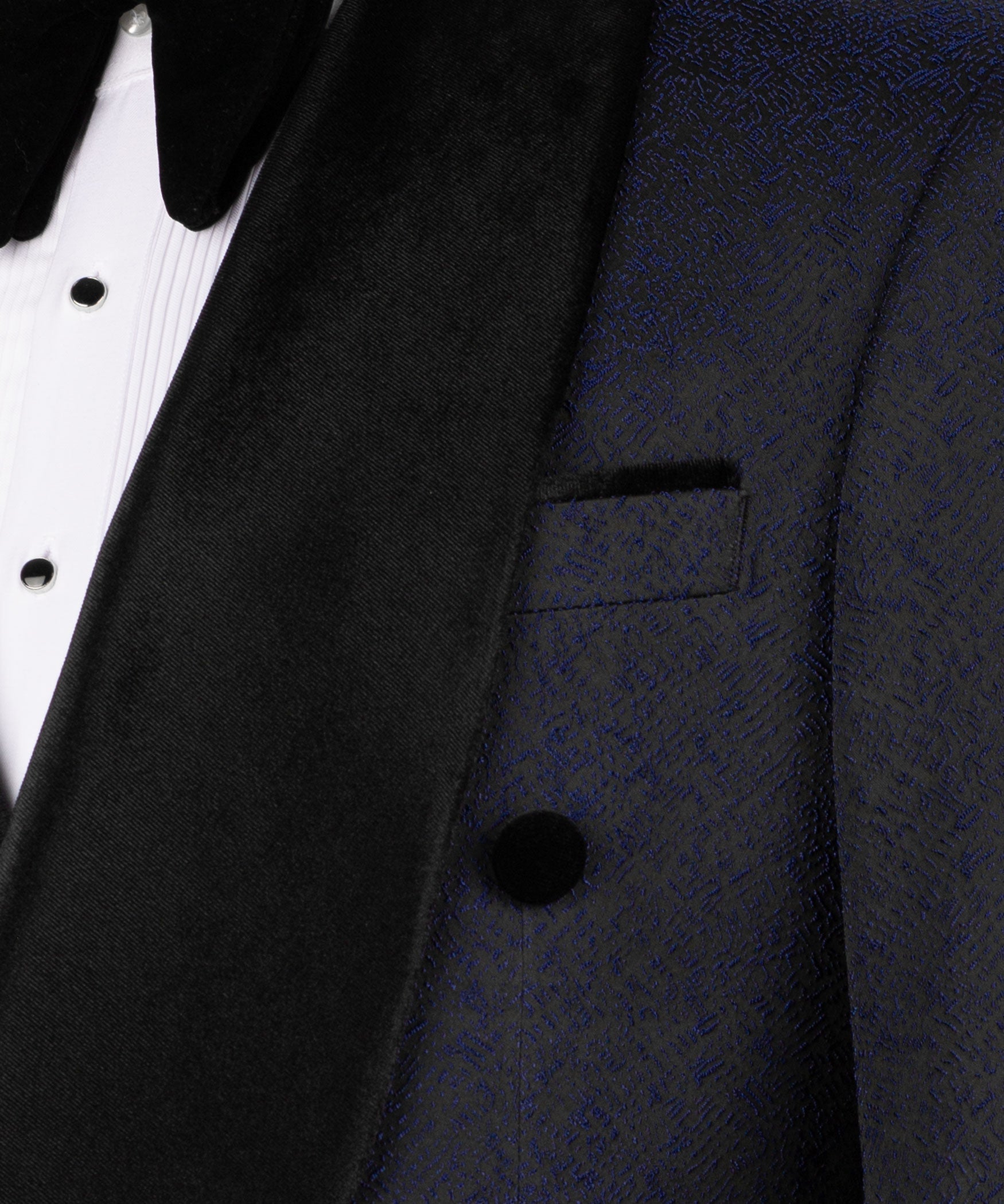 Close-up of black velvet tuxedo collar, lapel, and vest button on dark navy fabric