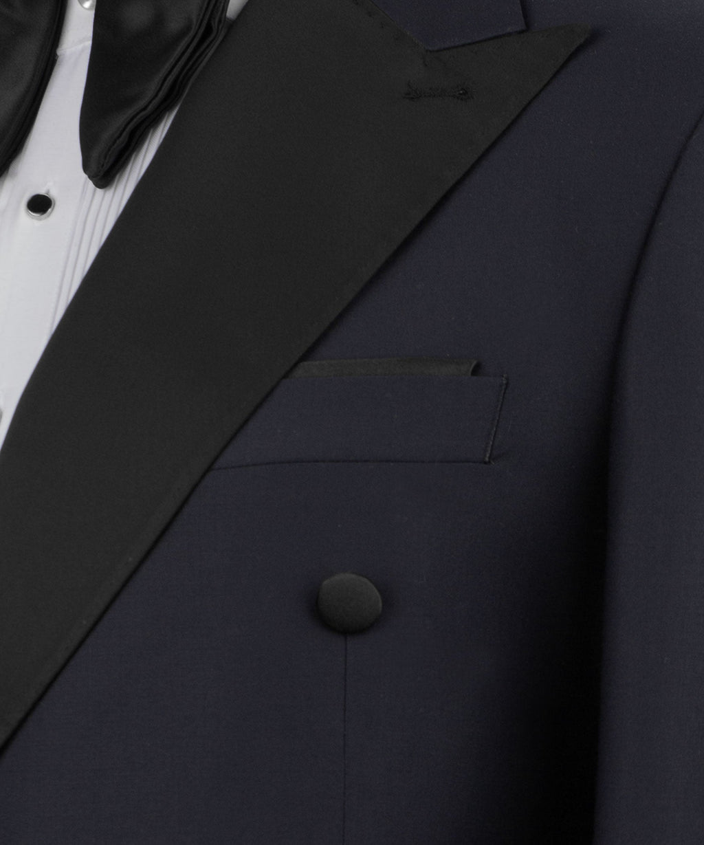 Close-up of navy tuxedo lapel with black satin trim, welt pocket and covered buttons