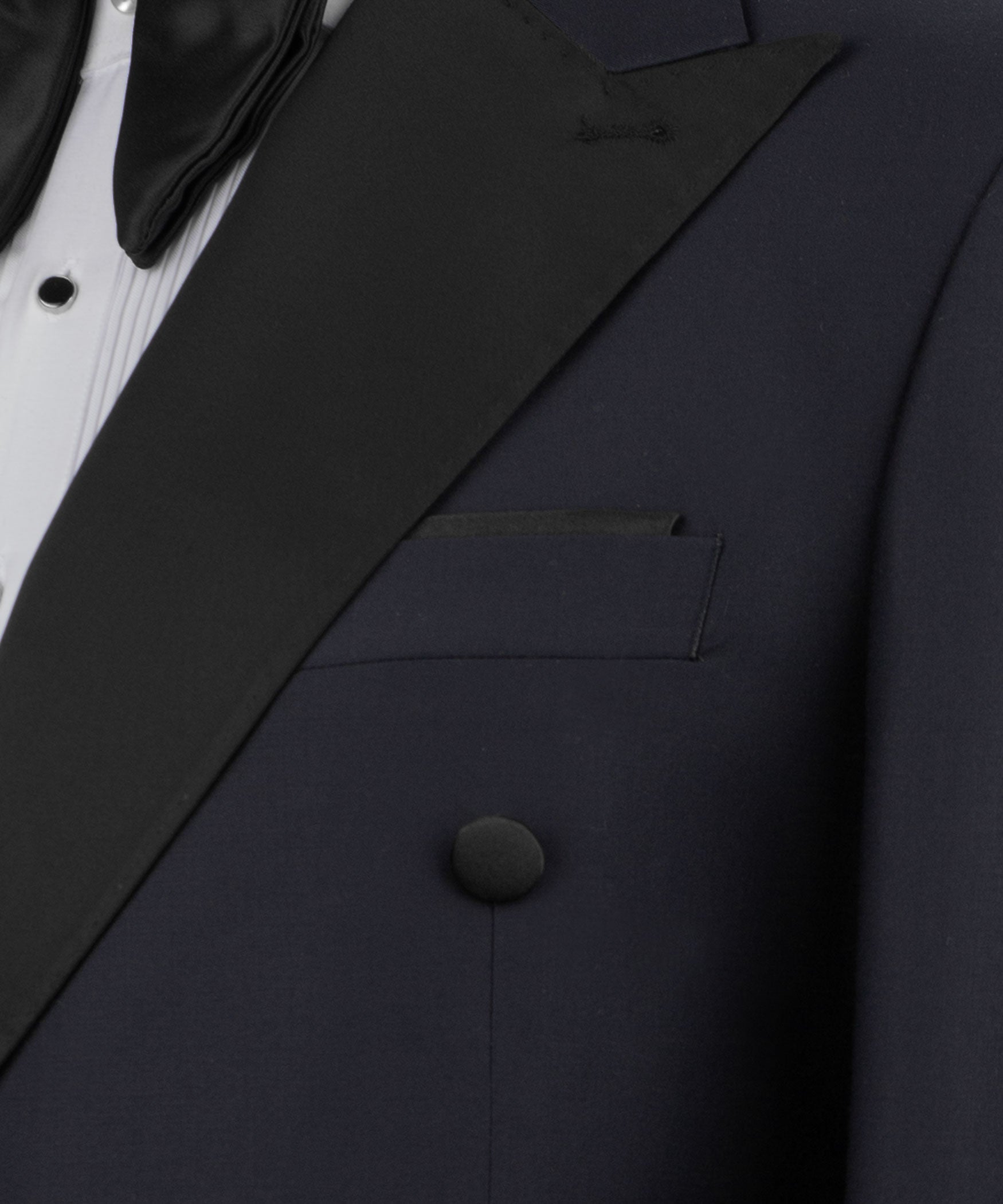 Close-up of navy tuxedo lapel with black satin trim, welt pocket and covered buttons