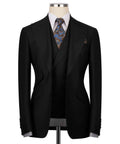 Black 3-piece formal suit: blazer, vest, and patterned necktie on mannequin