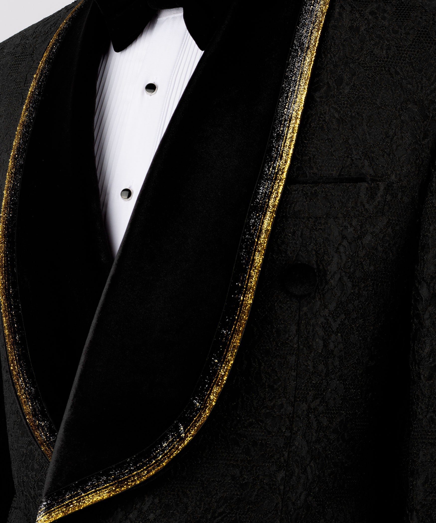 Close-up of black velvet lapels with gold embroidered trim and black satin vest