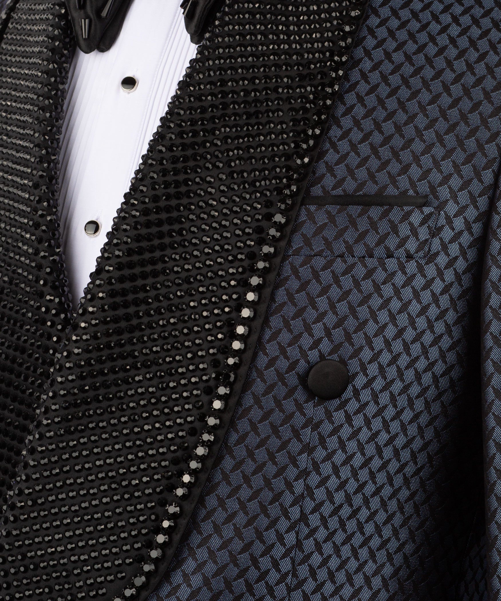 Close-up of black beaded embroidery on tuxedo lapel over white shirt placket
