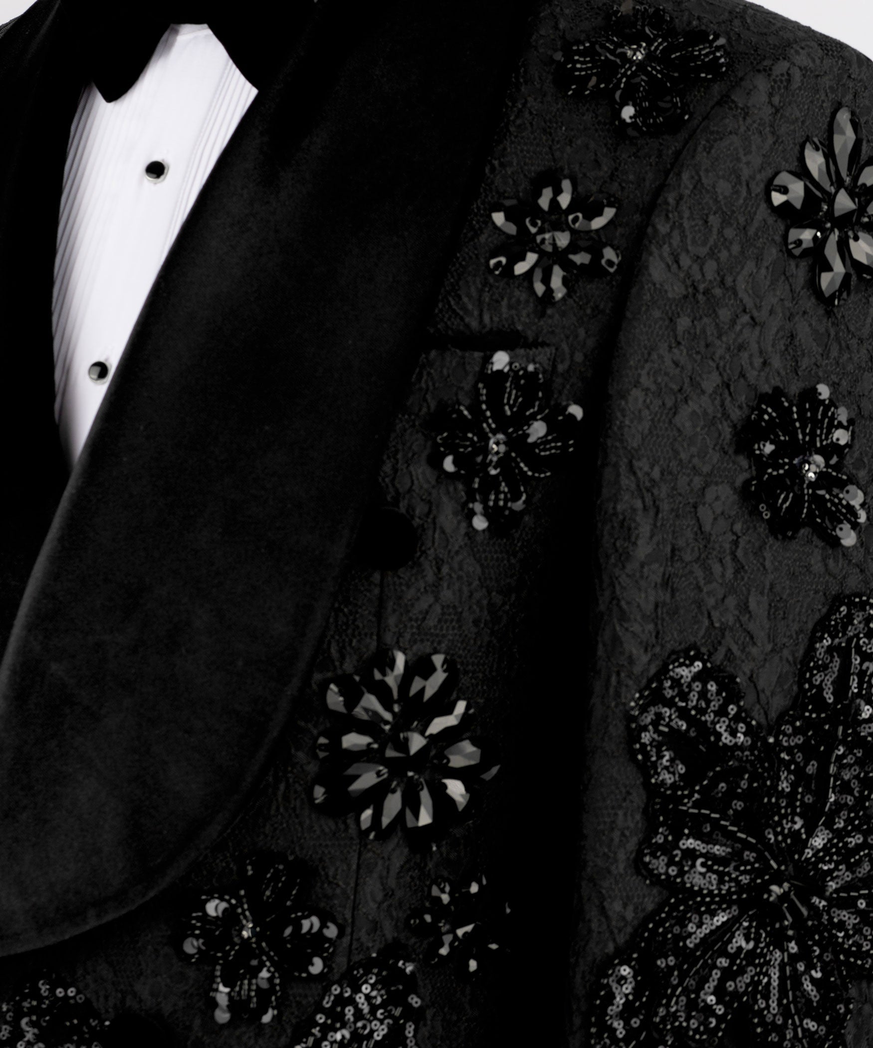 Close-up of black blazer fabric with hand-embroidered floral sequins appliqué