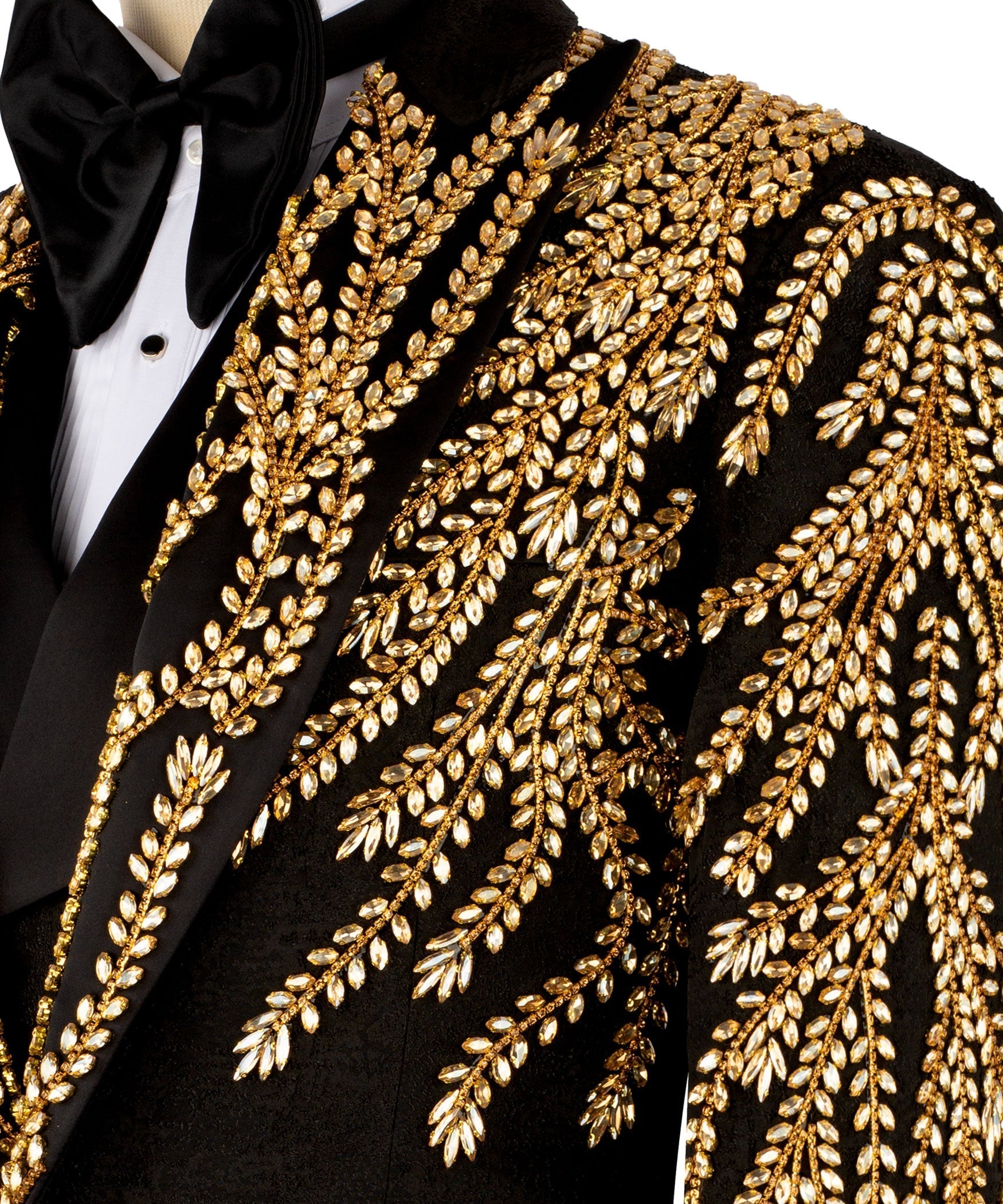 Close-up: black tuxedo jacket with ornate gold leaf-stitched embroidery on lapel