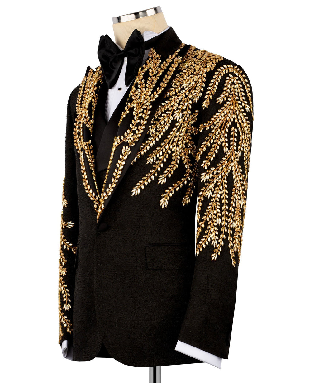 Black tuxedo jacket with dense gold embroidery on sleeves and structured lapel, bow tie