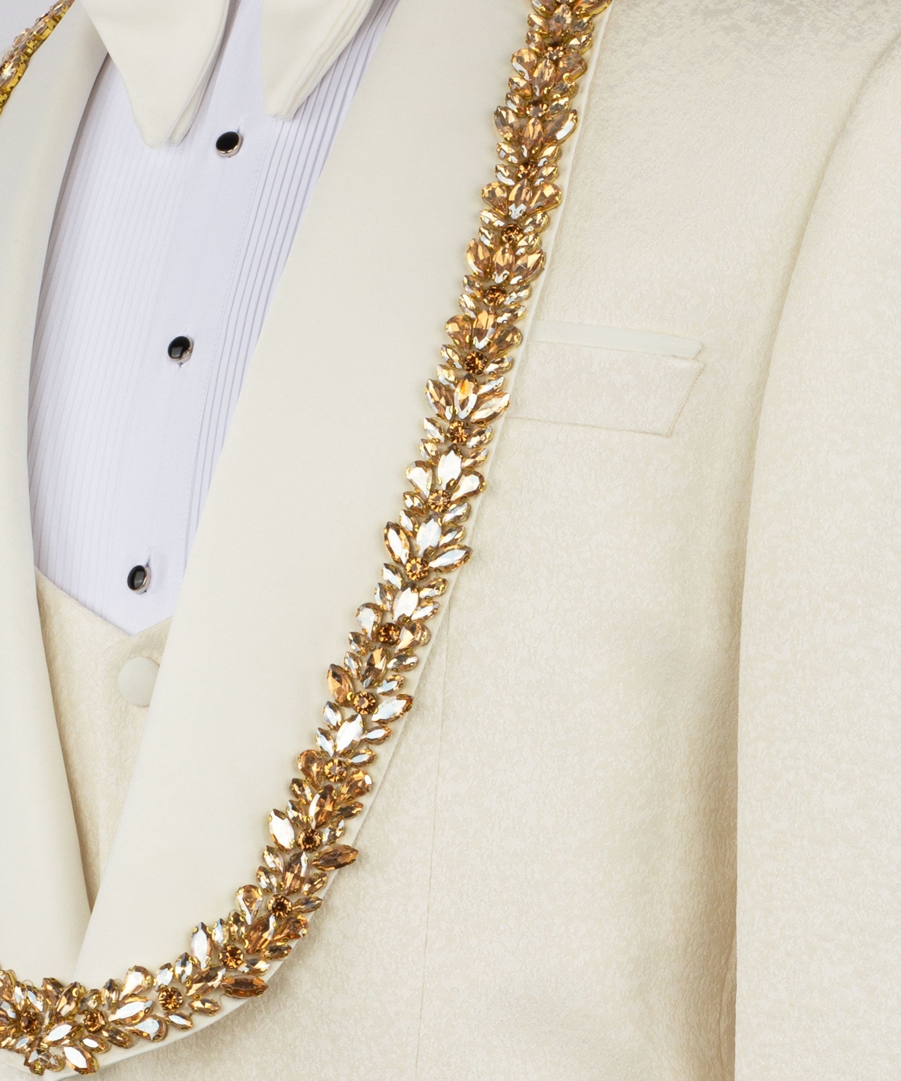 Close-up of gold stone-embellished trim along cream tuxedo lapel and vest