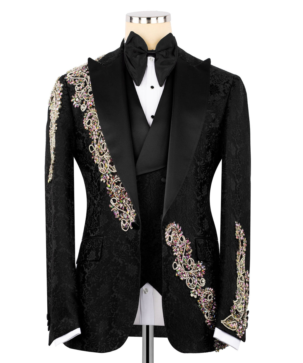 Black tuxedo jacket with black bow tie, white shirt, and jeweled gold/pink trim accents