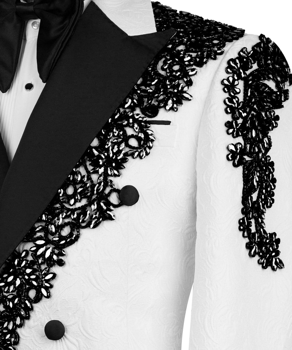 Close-up of black lapel and bow tie on white tuxedo jacket with ornate lace appliqué