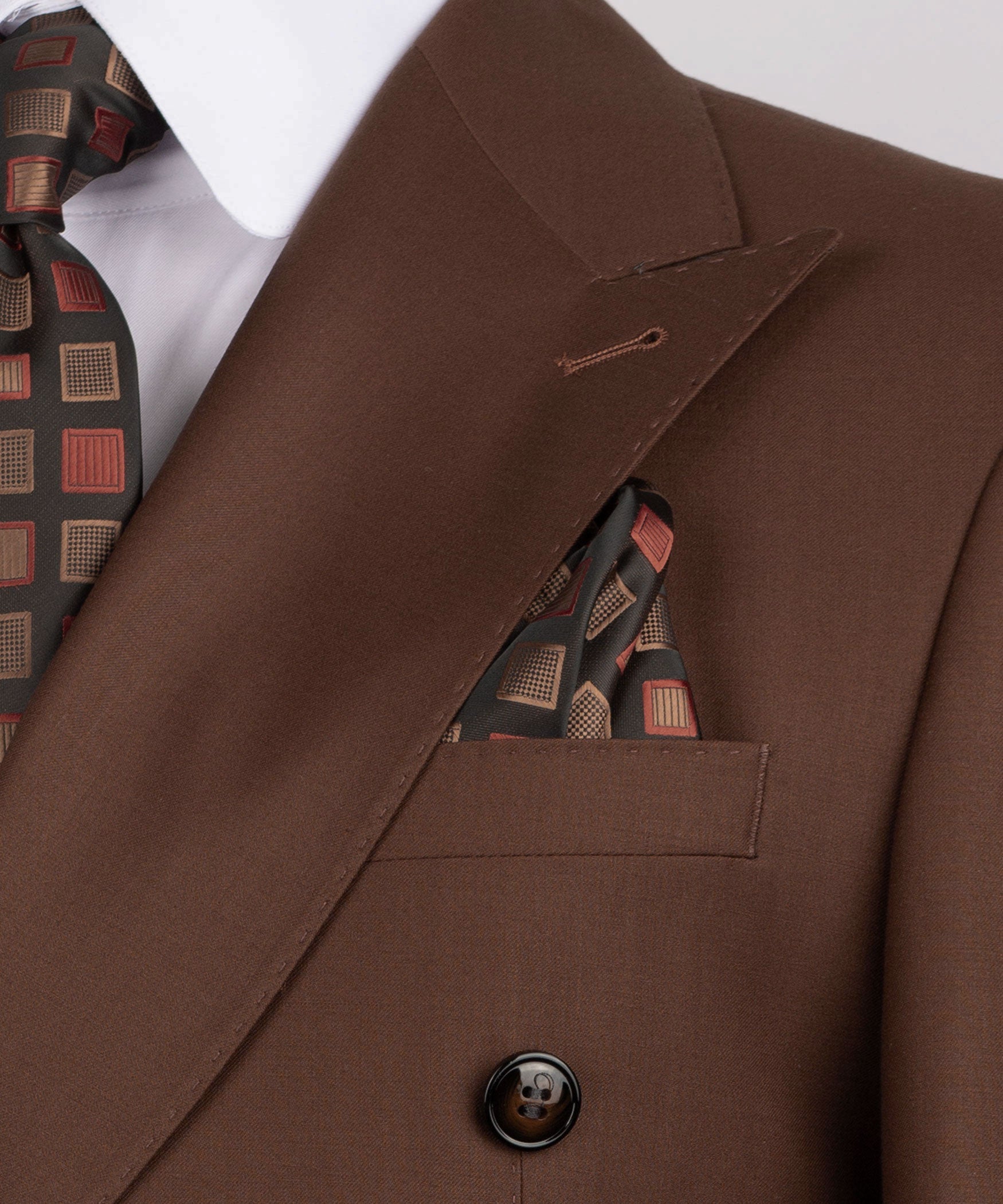 Close-up: dark brown jacket lapel, pocket flap, and round dark button with patterned lining