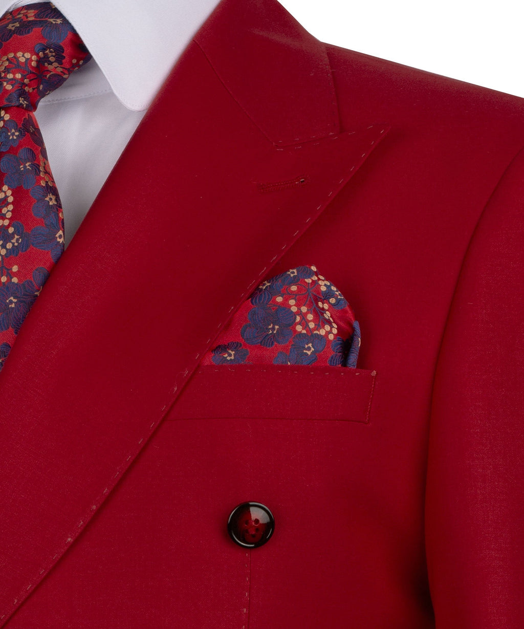Red suit jacket close-up: lapel and chest pocket with patterned pocket square, dark button