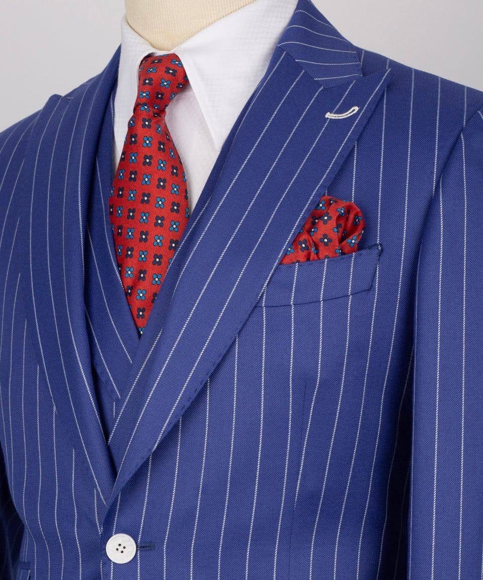 Blue pinstripe suit with red patterned tie and pocket square on a mannequin.