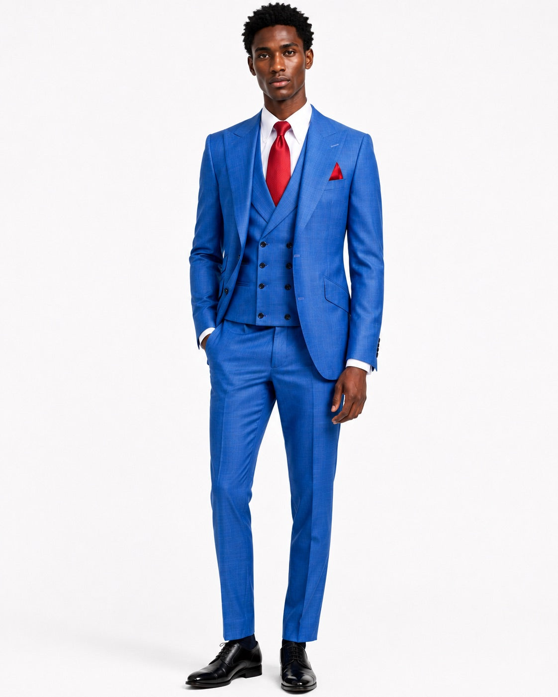A man modeling a bright blue three-piece suit with a matching vest and trousers, styled with a white dress shirt, a red tie, and a red pocket square.