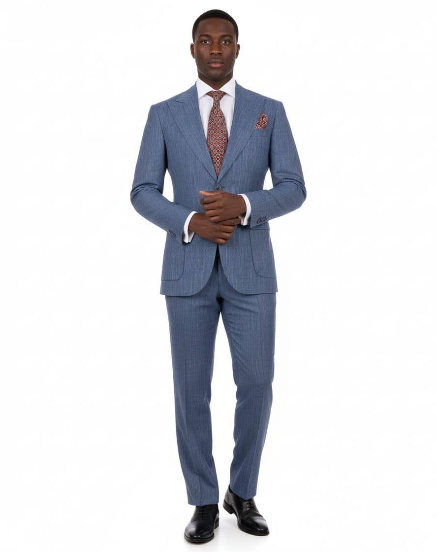A man modeling a blue pinstripe suit with a white dress shirt, a patterned reddish-brown tie, and black dress shoes, standing against a plain white background.