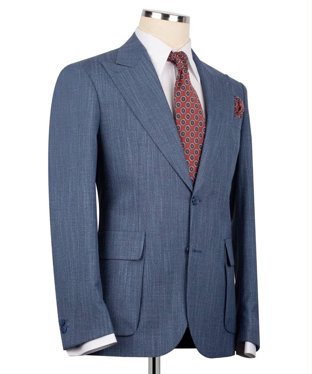 A blue pinstripe suit jacket displayed on a mannequin torso, styled with a white dress shirt and a red patterned tie.