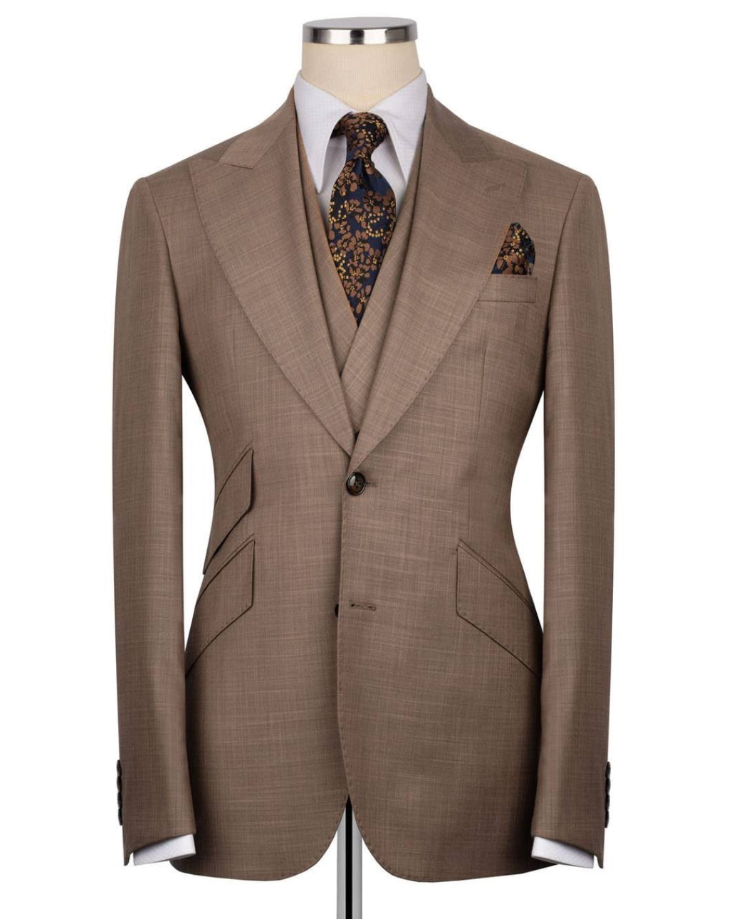Brown suit jacket on a mannequin with a white shirt, patterned tie, and pocket square.