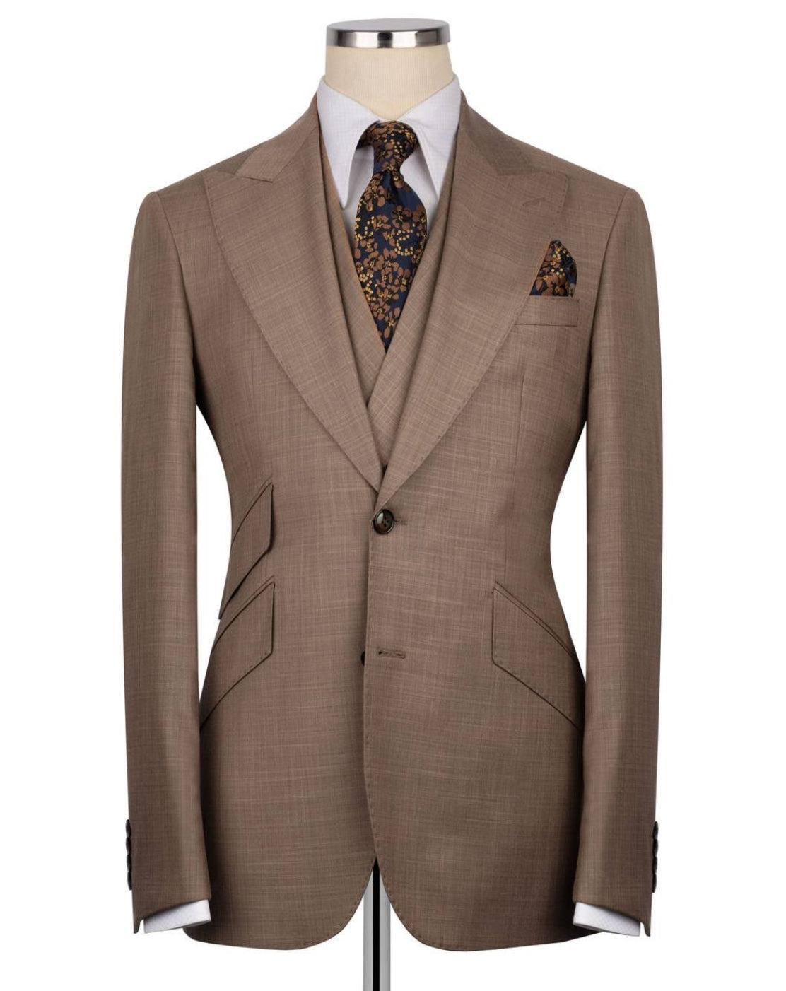 Brown suit jacket on a mannequin with a white shirt, patterned tie, and pocket square.