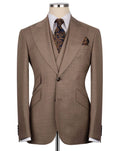 A brown single-breasted suit jacket displayed on a mannequin torso, styled with a white dress shirt, a patterned brown and gold tie, and a matching pocket square.
