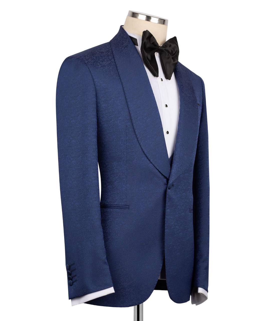Blue tuxedo jacket on a mannequin with a white shirt and black bow tie against a white background