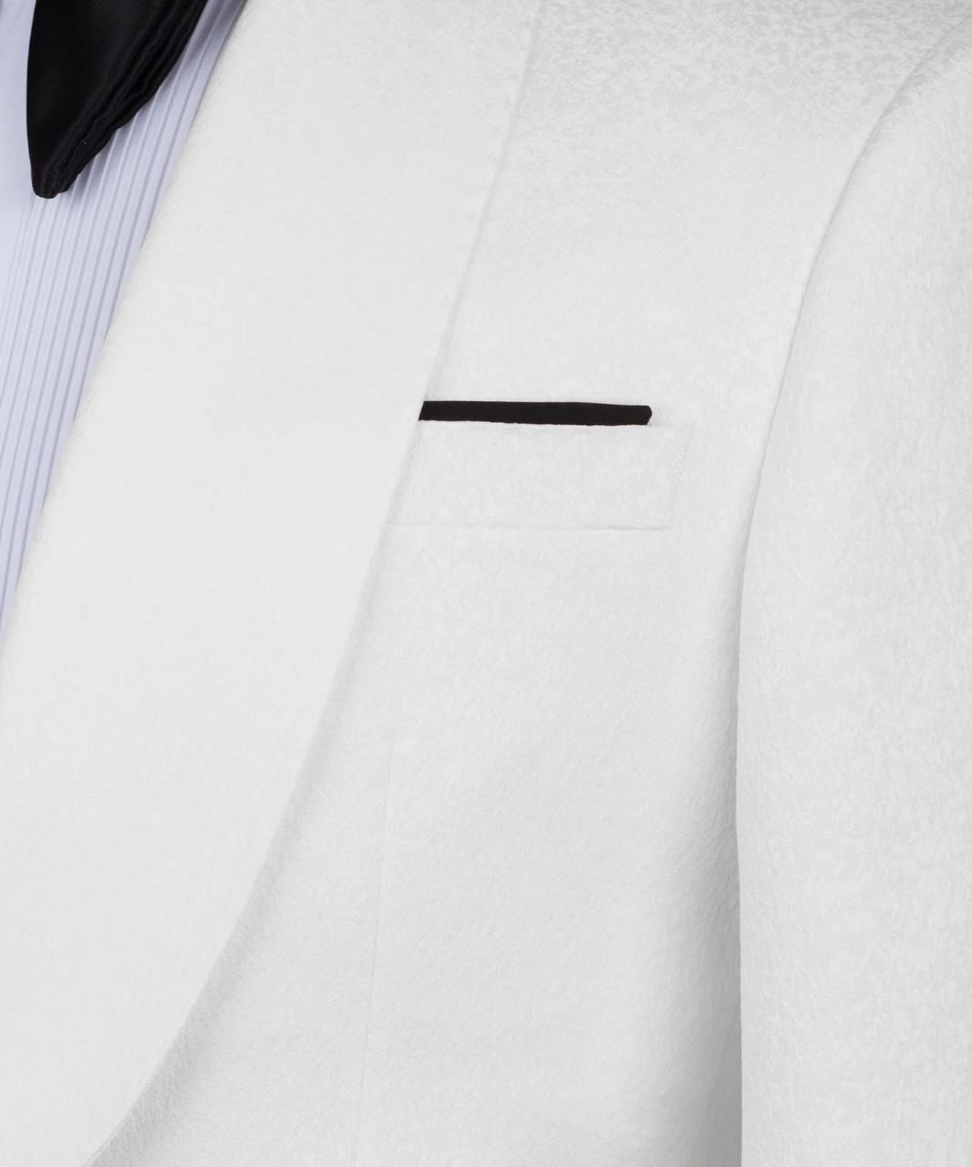 Close-up of a white textured suit jacket with a single black button detail on the chest pocket, worn over a light blue and white striped dress shirt.