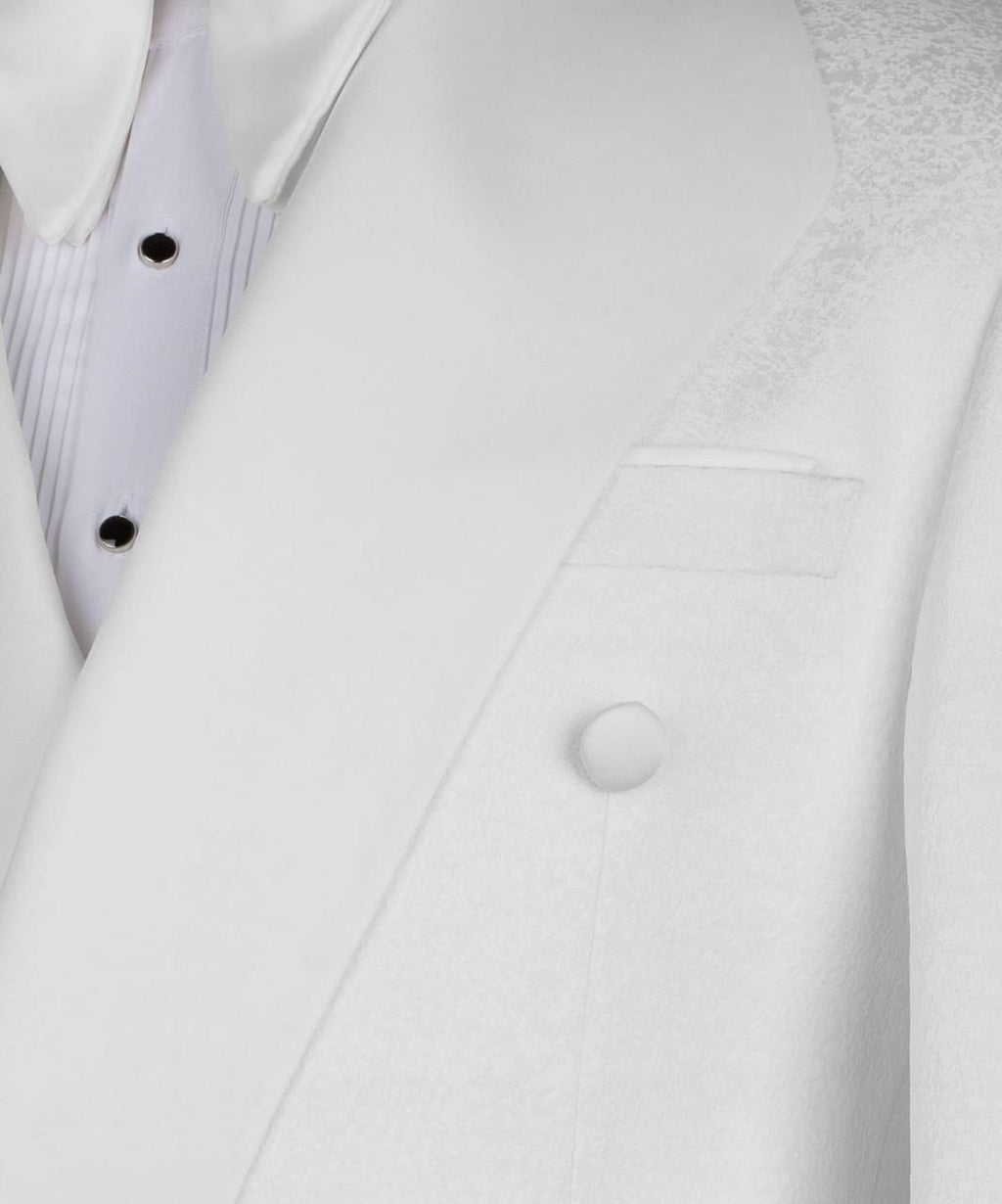 Close-up of a white double-breasted suit jacket with a single visible button, showing part of a white pleated shirt underneath.