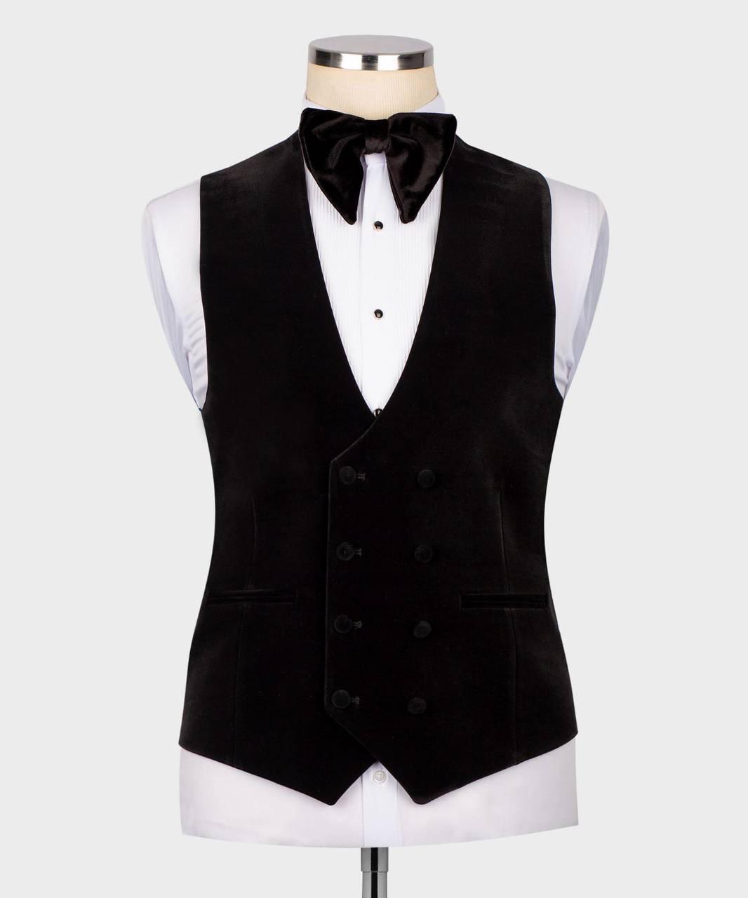 A black double-breasted velvet tuxedo vest displayed on a white dress shirt and bow tie mannequin against a light gray background.