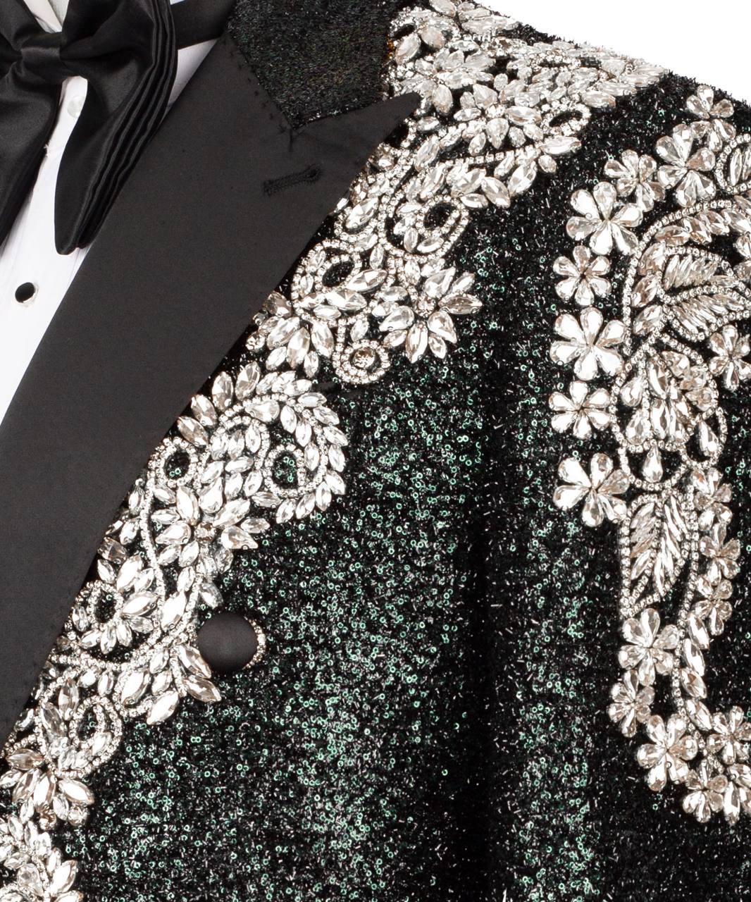 Close-up of a black tuxedo with silver floral embroidery on a dark background