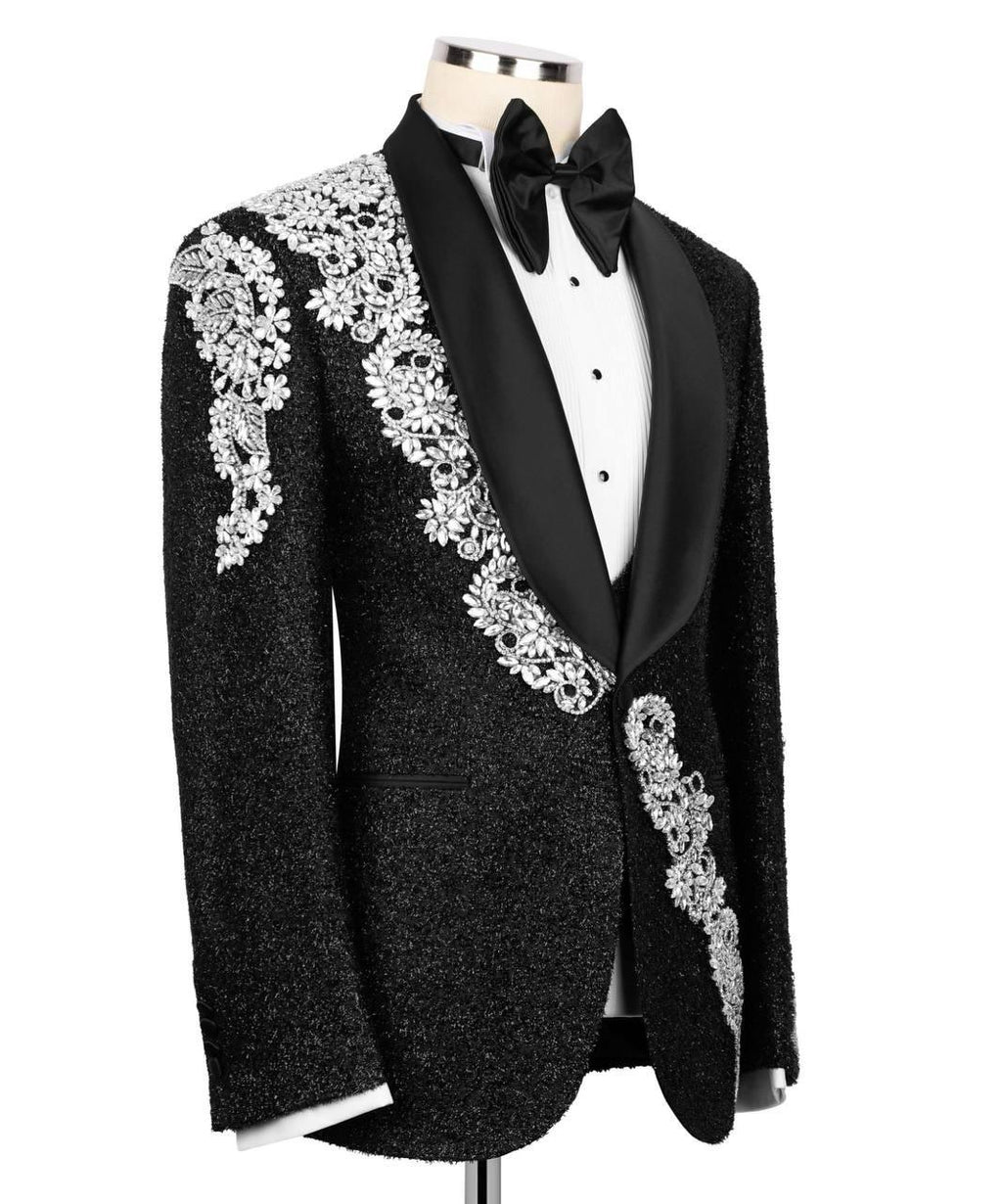 Black tuxedo with white lace detailing on a mannequin against a white background