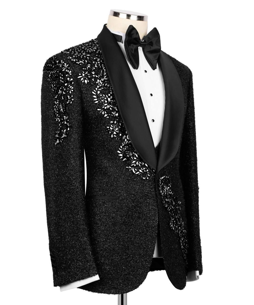 Black tuxedo with floral embroidery on a mannequin against a white background