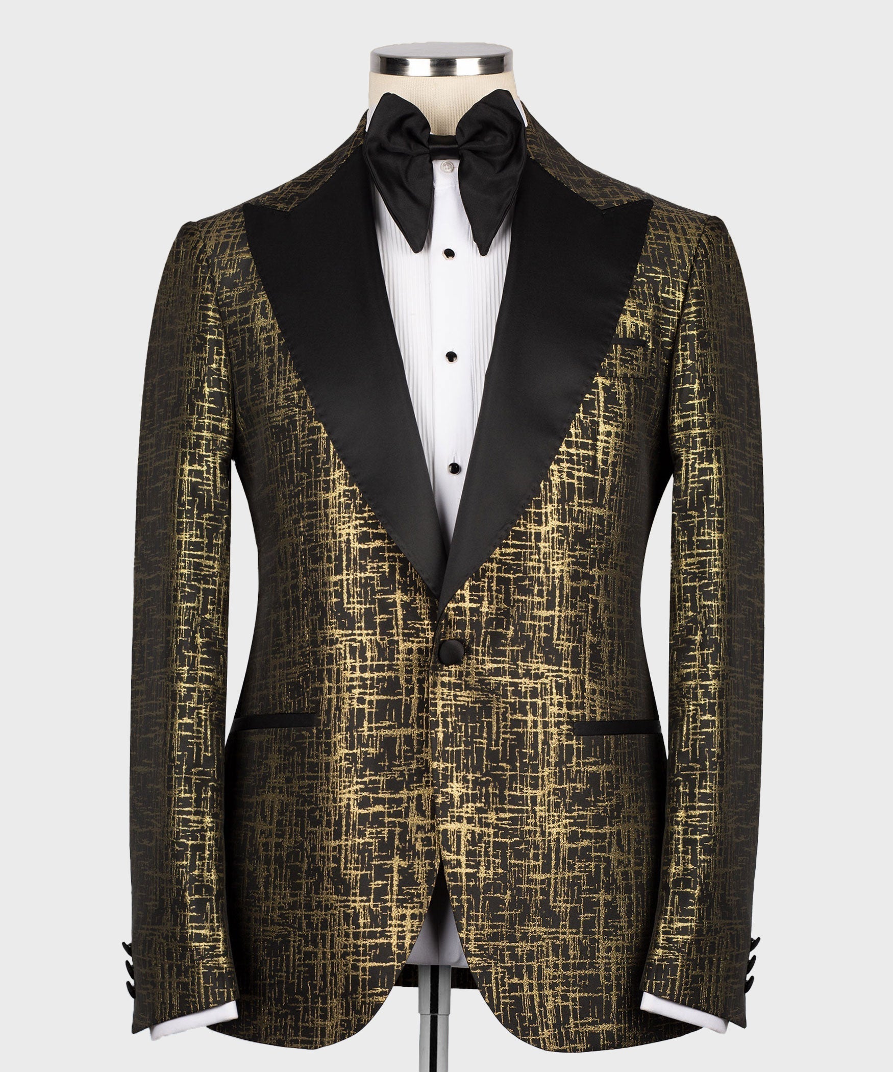 Black bow tie and pointed-collar white shirt under gold patterned tuxedo jacket